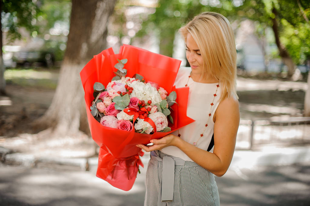 Femme tenant une composition colorée de fleurs
 - Photo, image