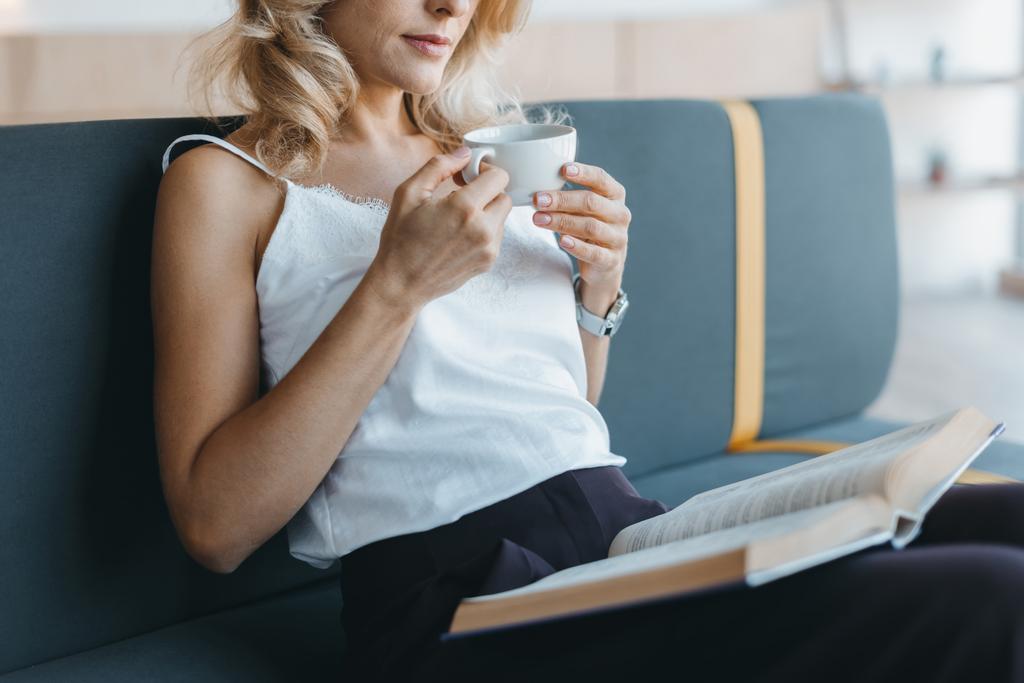 woman reading book and drinking coffee  - Photo, Image