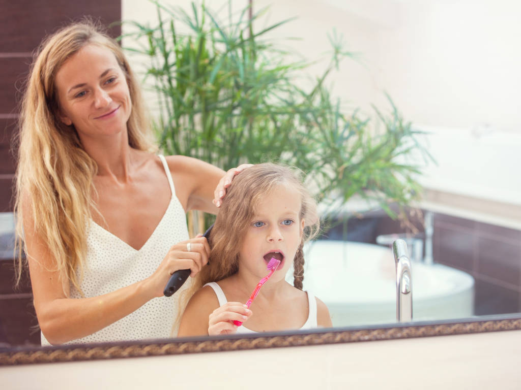 Mother and daughter brushing their teeth - Photo, Image