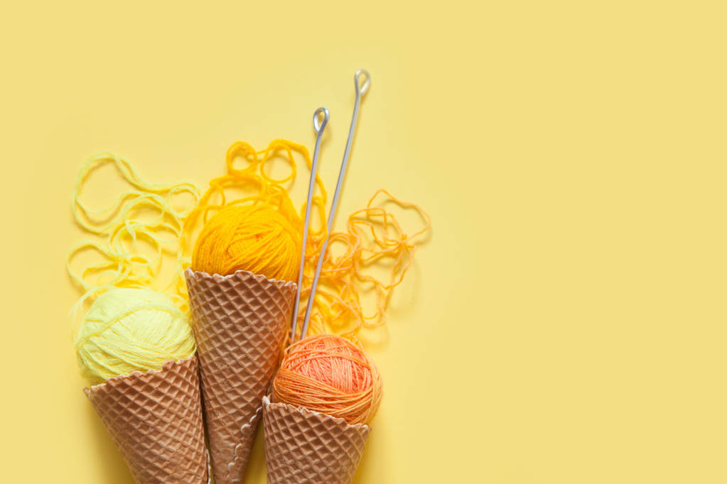 Las bolas de hilo se encuentran en un cono de gofre para helado. Lana de colores
. - Foto, Imagen