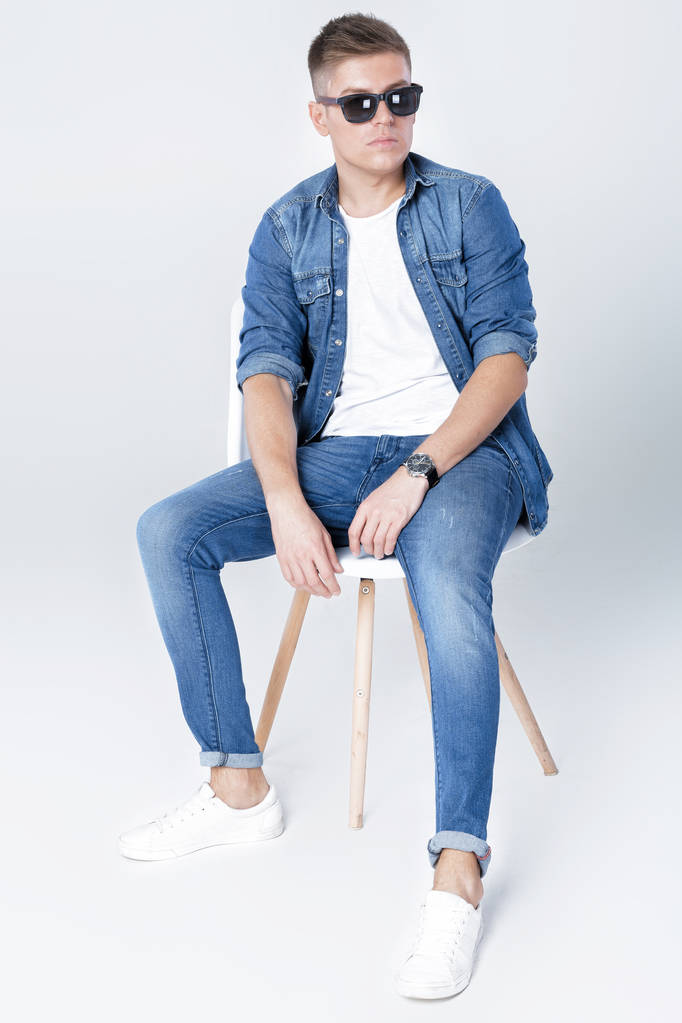 handsome man in denim sits on chair - Photo, Image