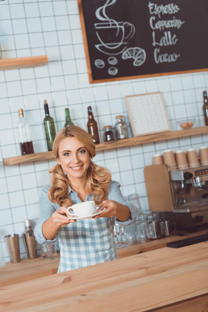 Kellnerin schenkt Becher mit Kaffee - Foto, Bild