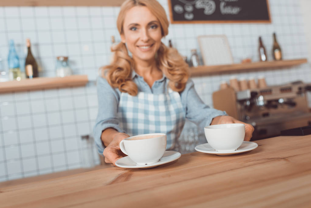 kelnerka gospodarstwa filiżanek kawy  - Zdjęcie, obraz