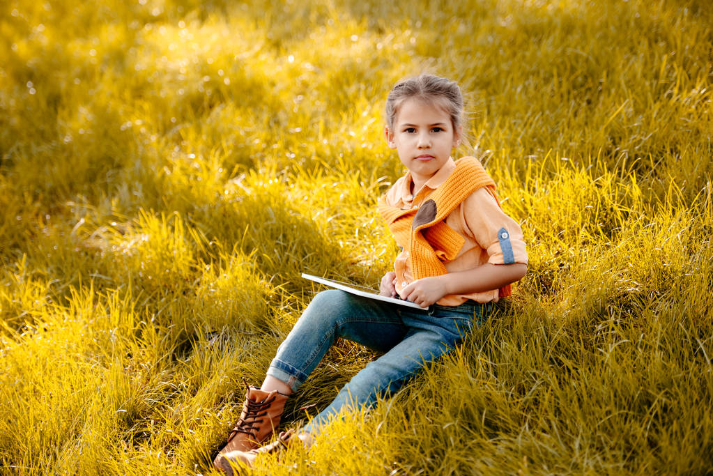 το παιδί χρησιμοποιώντας ψηφιακή δισκίο στο πάρκο - Φωτογραφία, εικόνα