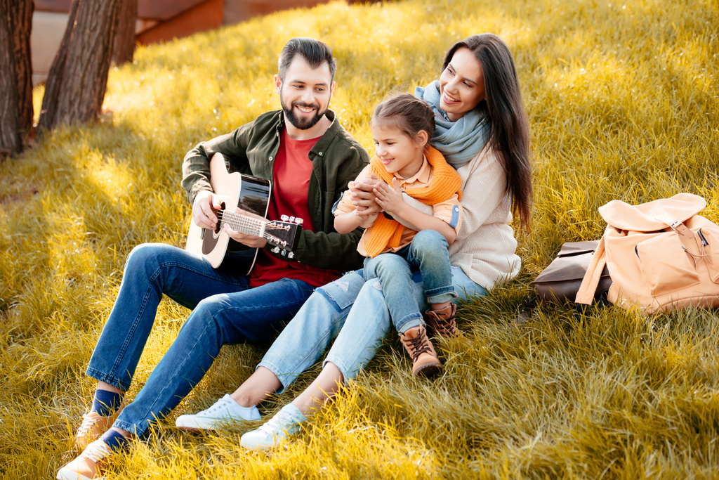 Junger Mann spielt mit Familie Gitarre - Foto, Bild