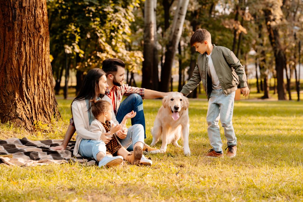 Familia jugando con el perro en el parque
 - Foto, imagen