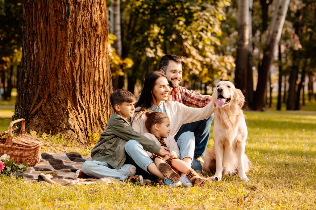 Οικογένεια στο σκυλί χάιδεμα πικ-νικ - Φωτογραφία, εικόνα