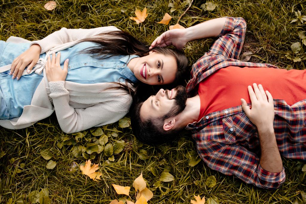 молодая пара лежит на траве - Фото, изображение