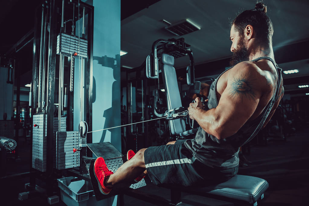 Ισχυρή Bodybuilder κάνει βαρύ βάρος άσκηση για πίσω στη μηχανή - Φωτογραφία, εικόνα