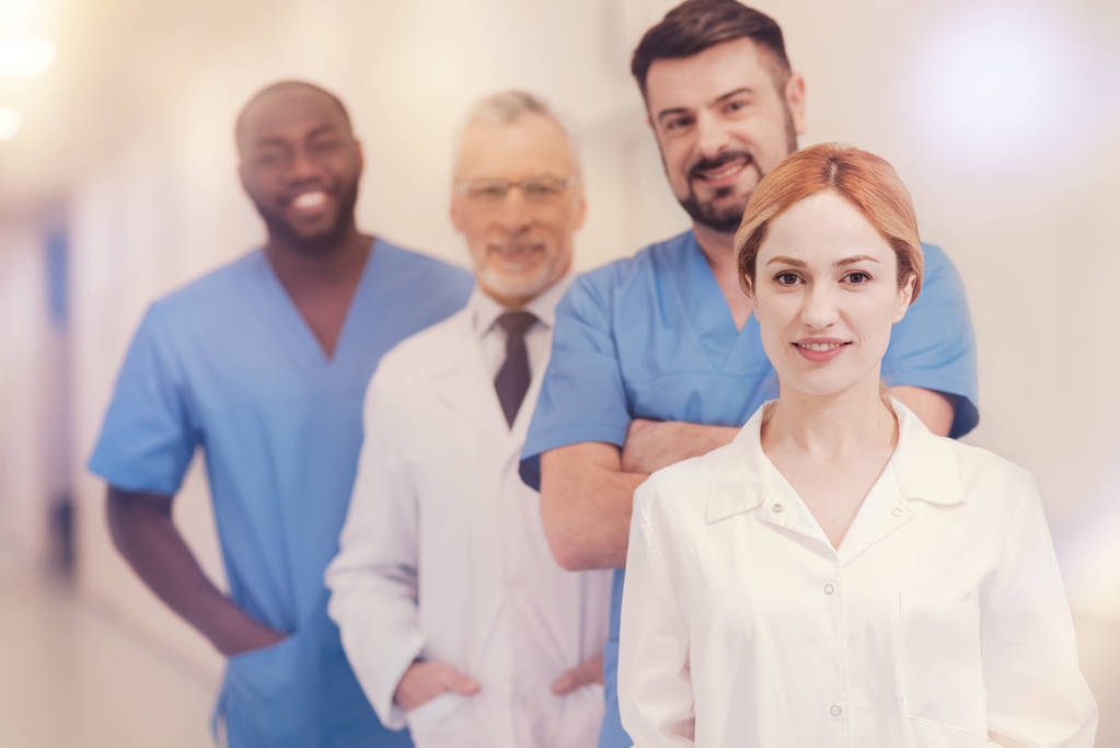 Привабливий жіночий медичний працівник стоїть на передньому плані
 - Фото, зображення