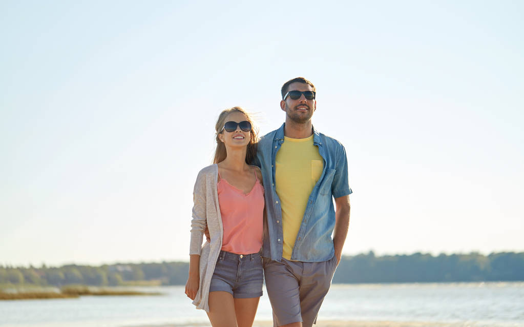 felice coppia in occhiali da sole che si abbraccia sulla spiaggia estiva
 - Foto, immagini