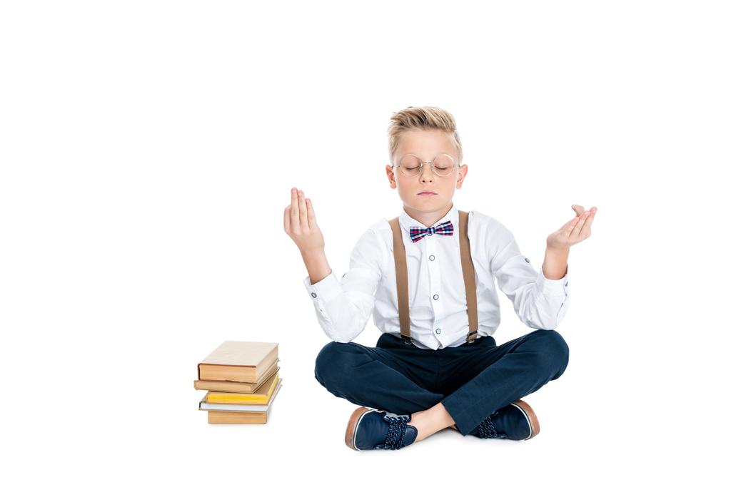 мальчик медитирует с книгами
 - Фото, изображение