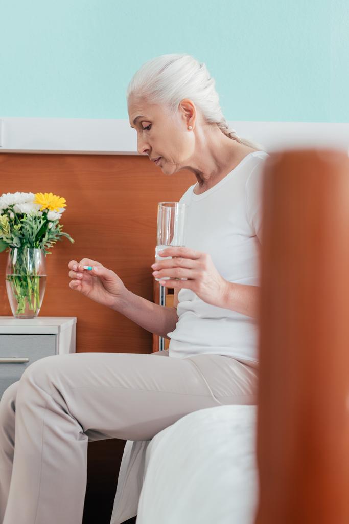 Oudere vrouw die medicijnen neemt - Foto, afbeelding