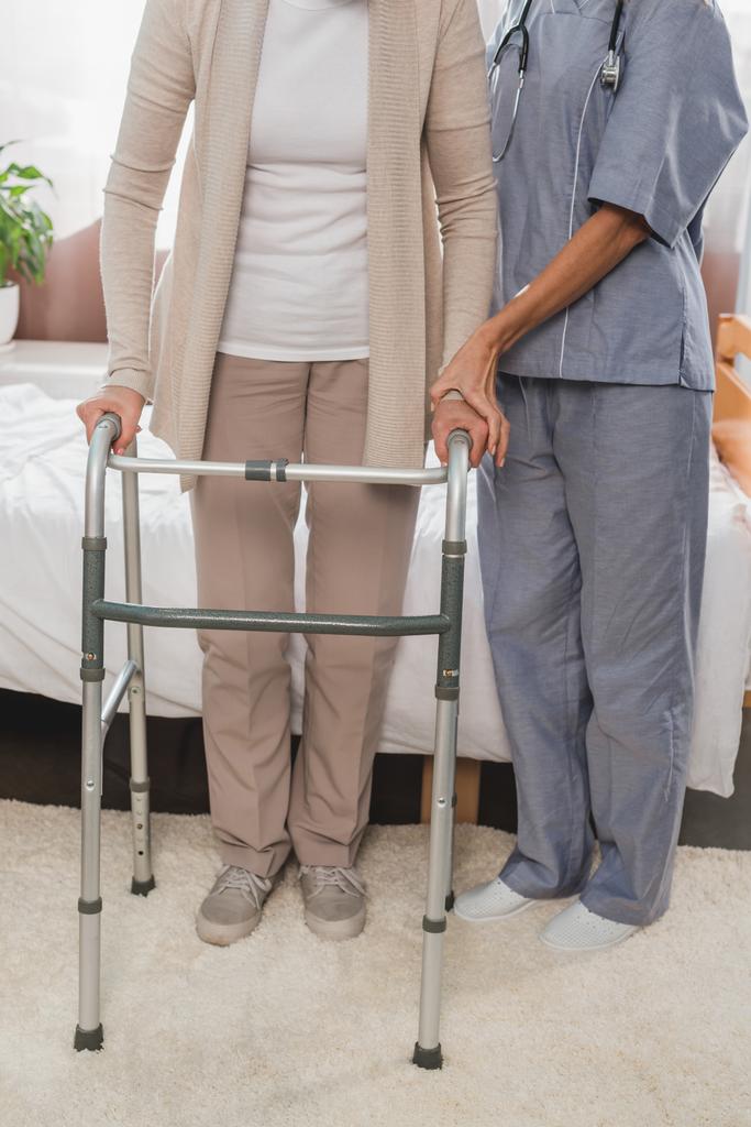 verpleegkundige en senior patiënt met walker - Foto, afbeelding