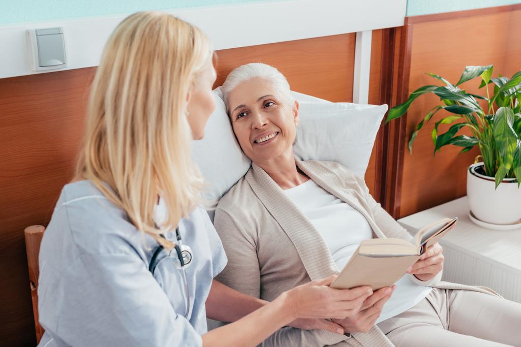 nurse and senior patient with book - Photo, Image