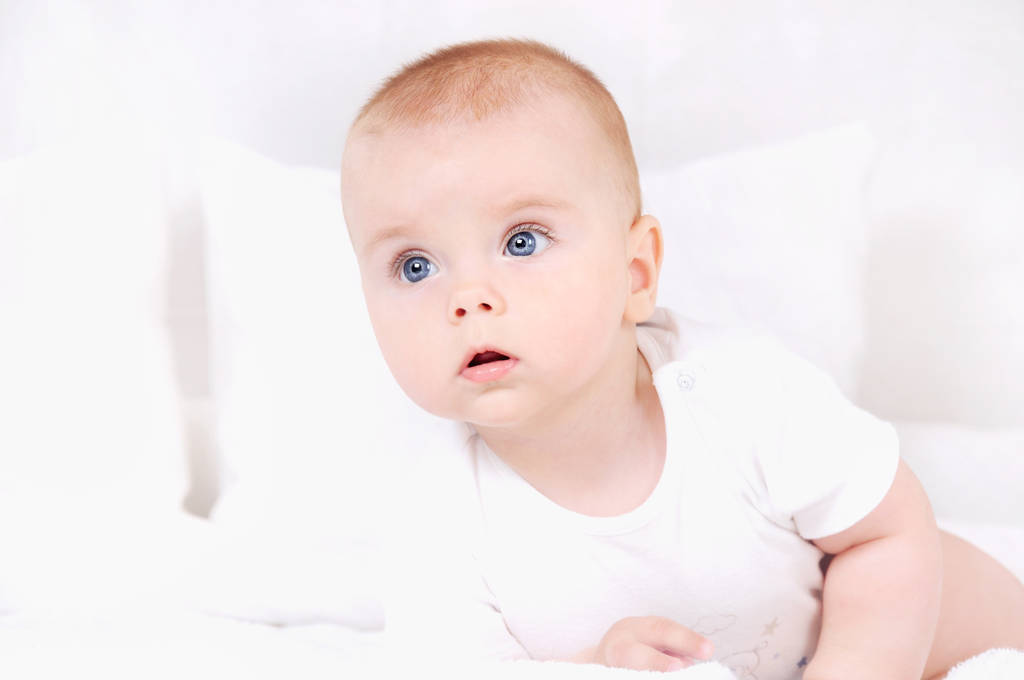 Hauska vauva pikkulapsi, jolla on siniset silmät sängyllä
 - Valokuva, kuva