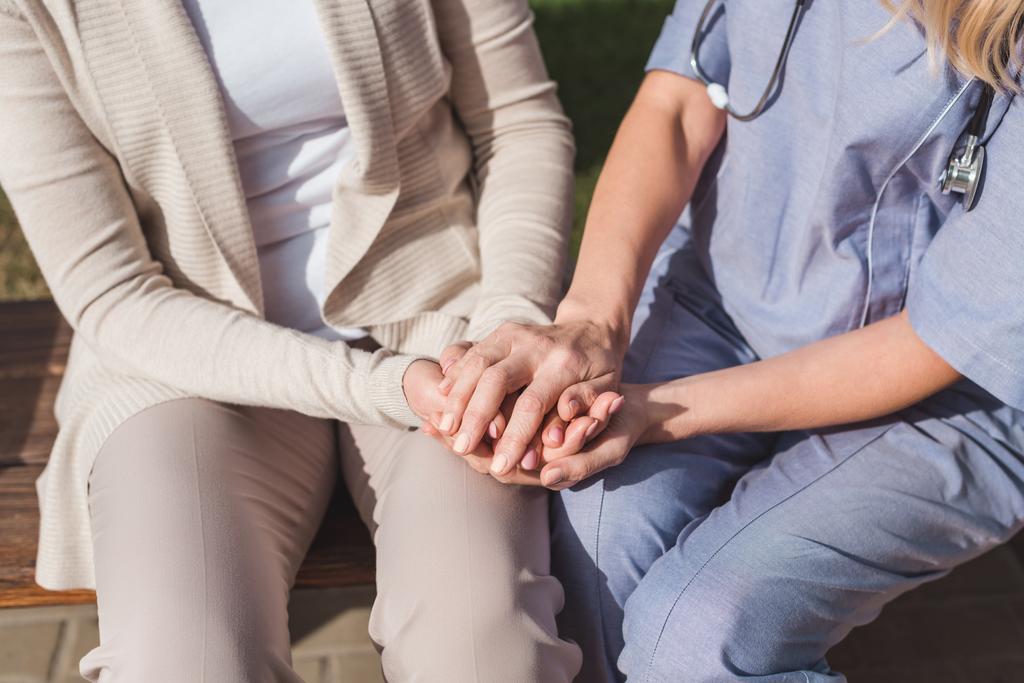νοσοκόμα και ασθενή, κρατώντας τα χέρια - Φωτογραφία, εικόνα