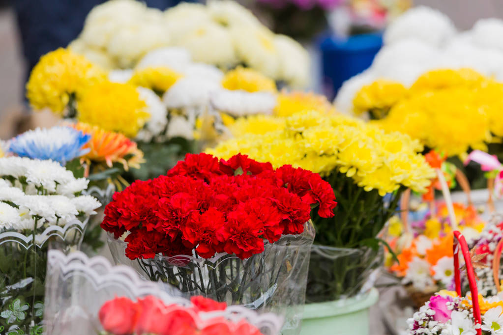 Kimppu punaisia neilikoita ja muita kukkia myydään kaupungin markkinoilla
. - Valokuva, kuva