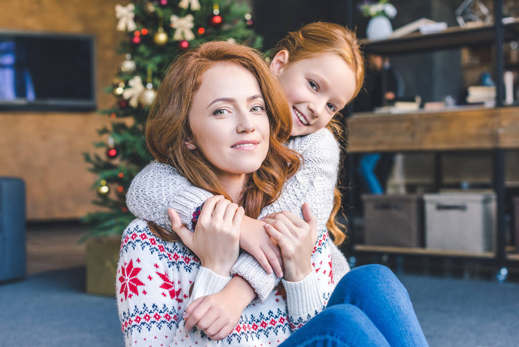 mother and daughter embracing on christmas - Photo, Image
