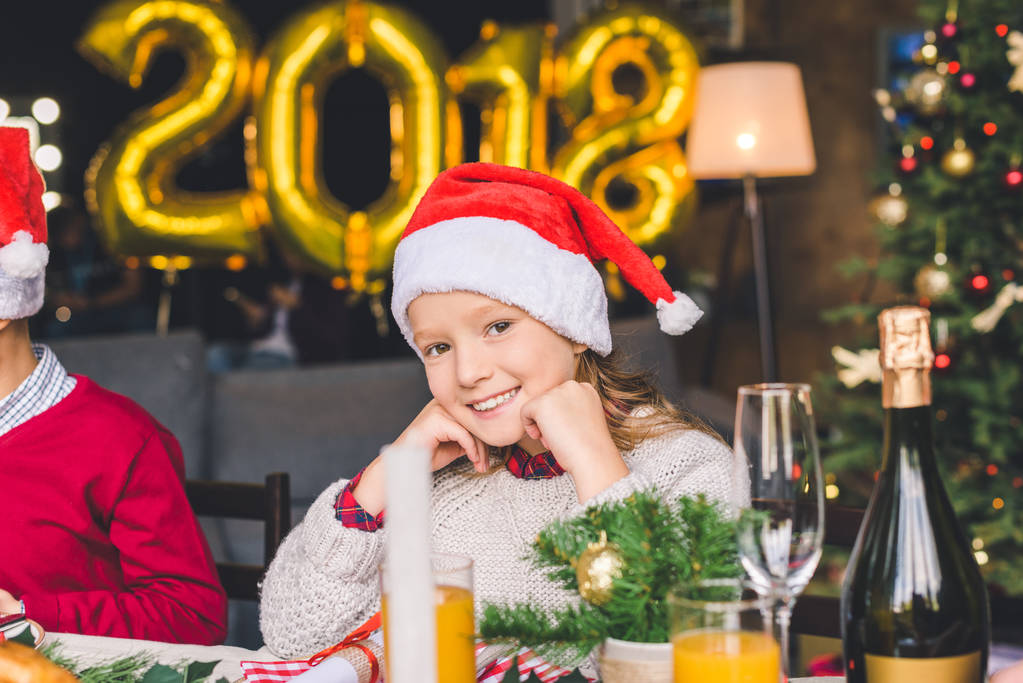 menina sentada na mesa de Natal
 - Foto, Imagem