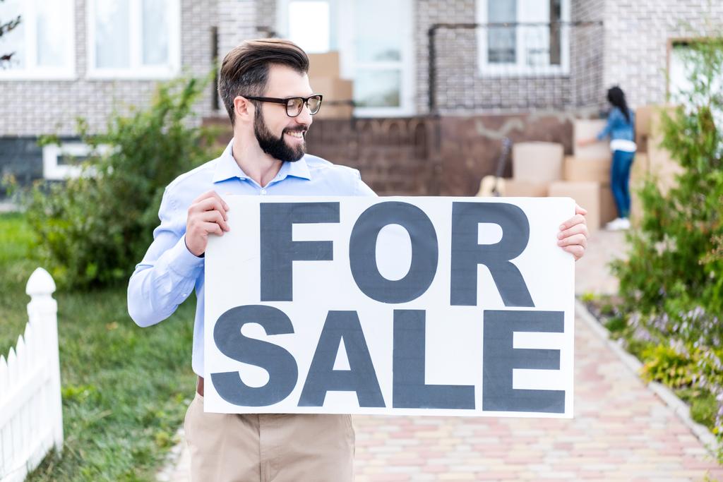 agente inmobiliario con banner en venta
 - Foto, Imagen