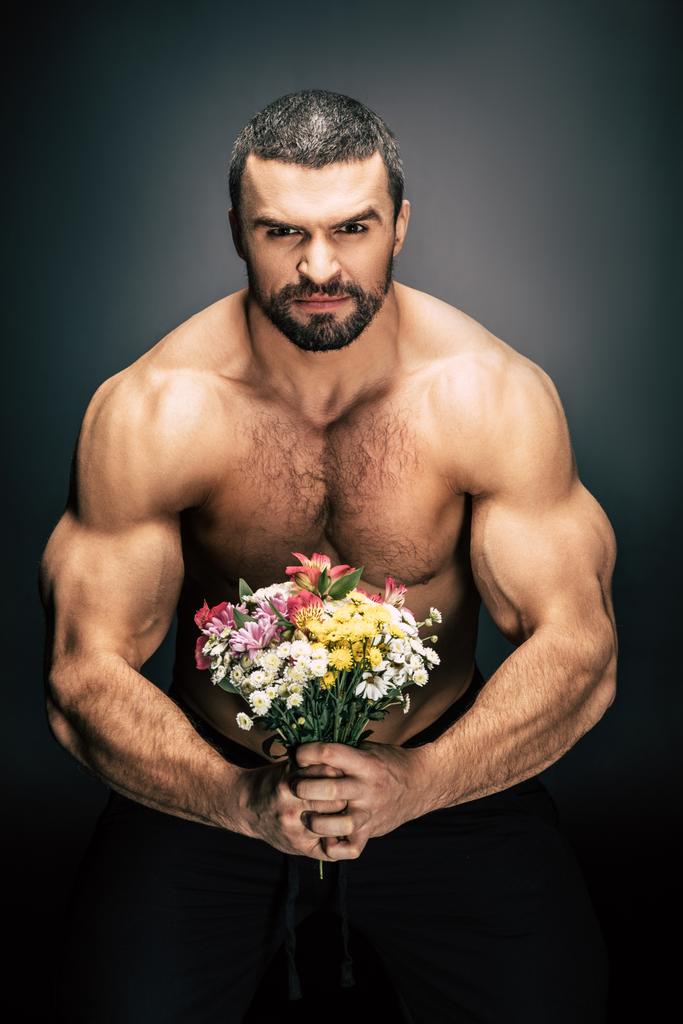sportive man with bouquet of flowers - Photo, Image