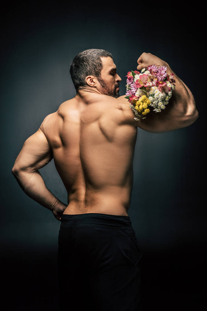 sportive άνθρωπος με μπουκέτο λουλούδια - Φωτογραφία, εικόνα