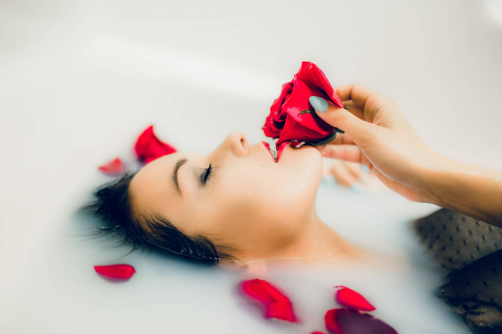 vrouw met rode roos in badkamer - Foto, afbeelding