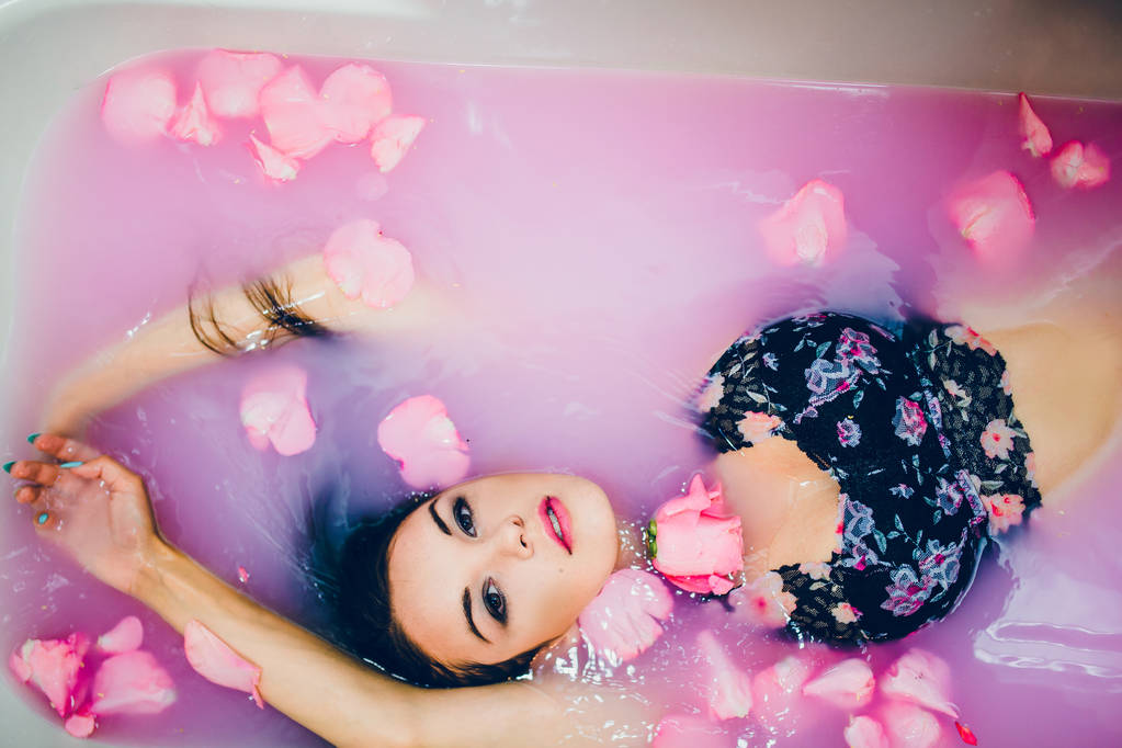 γυναίκα σε ροζ νερό και πέταλα - Φωτογραφία, εικόνα