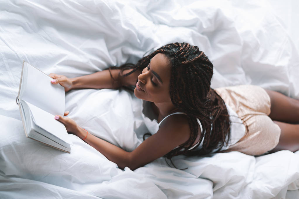 Γυναίκα ανάγνωση βιβλίο στο κρεβάτι - Φωτογραφία, εικόνα