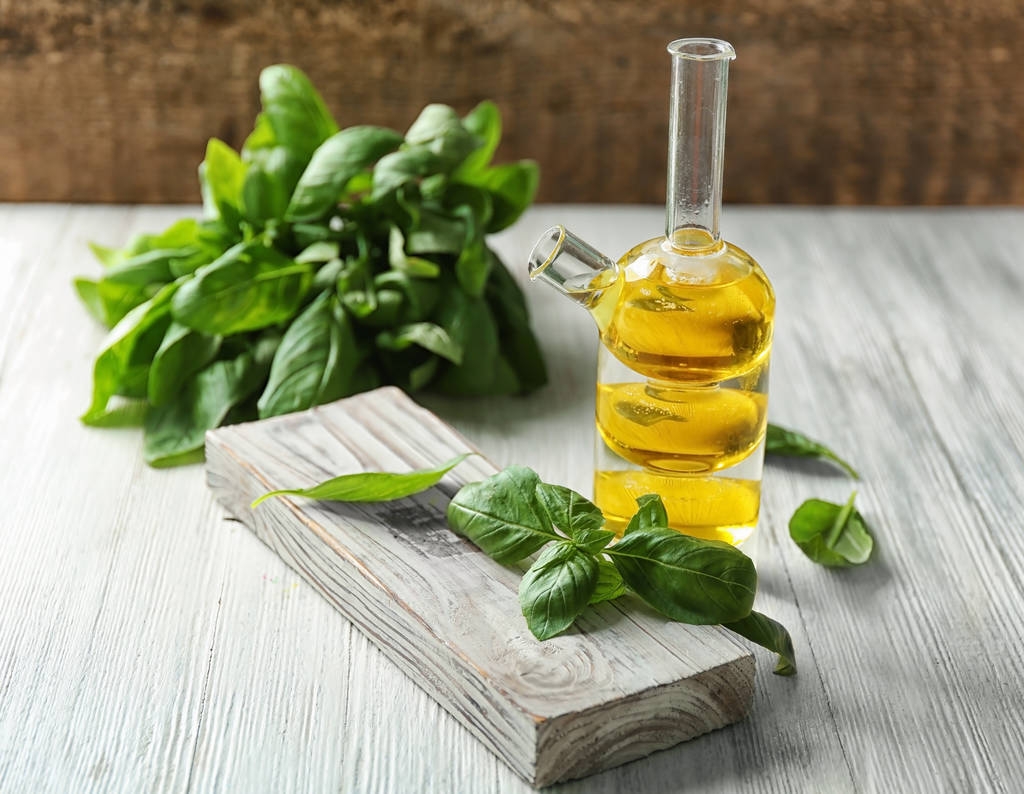 Бутылка с базиликовым маслом и зелеными листьями
 - Фото, изображение