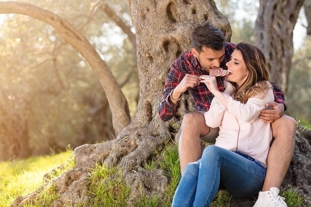 Young beautiful couple under tree in beautiful nature. - Photo, Image