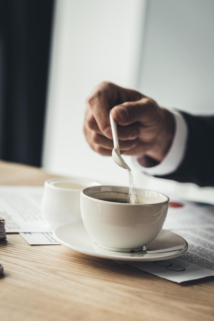 コーヒーに砂糖を追加するビジネスマン - 写真・画像