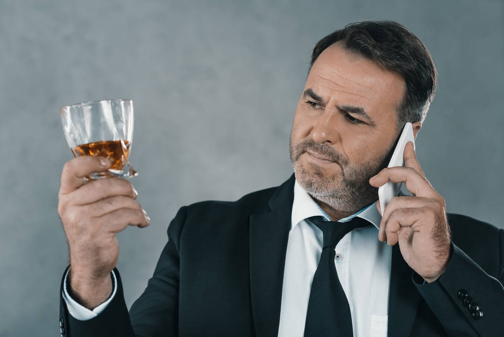 Telefonla konuşurken viski cam ile işadamı - Fotoğraf, Görsel