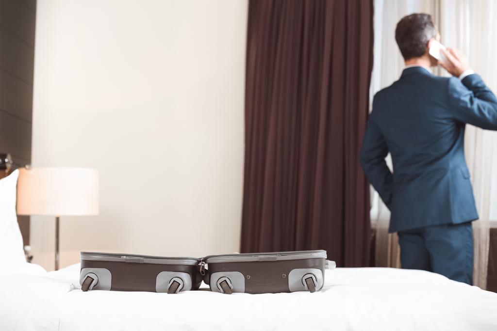 Podnikatel mluví o telefonu v hotelovém pokoji - Fotografie, Obrázek