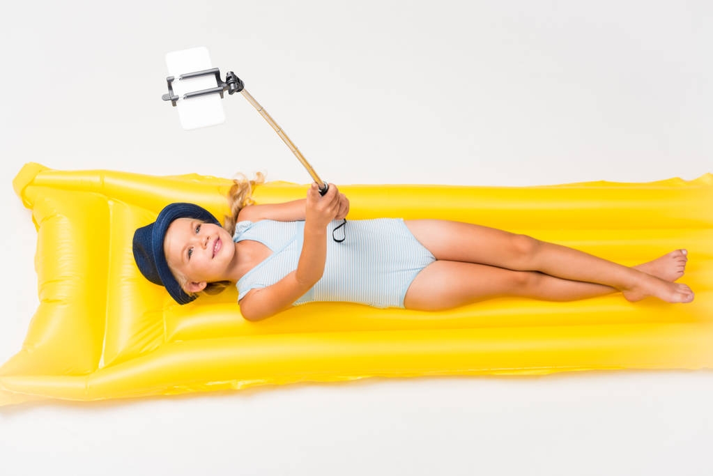 child taking selfie of swimming mattress - Photo, Image