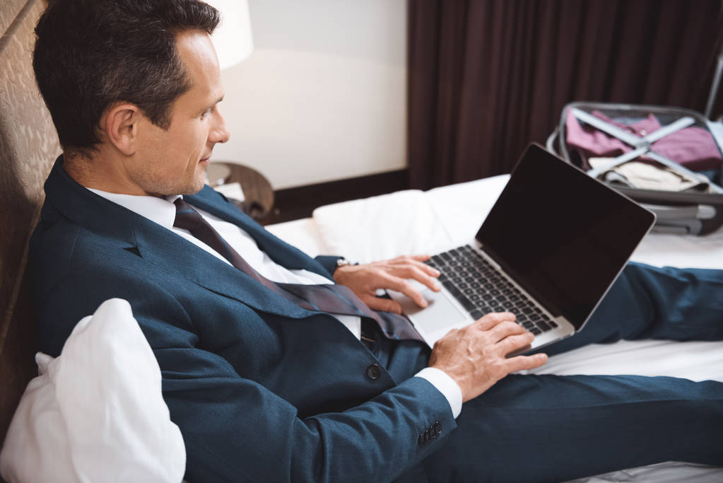 hombre de negocios en la cama trabajando con el ordenador portátil
 - Foto, imagen