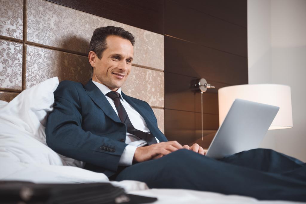 homem de negócios na cama trabalhando com laptop
 - Foto, Imagem