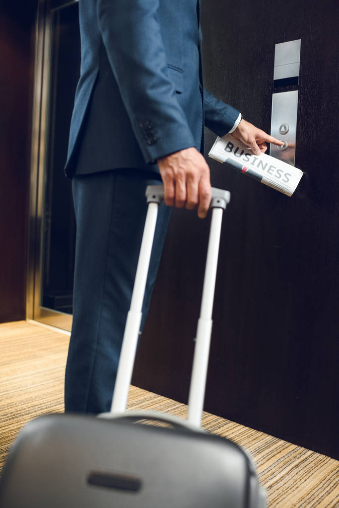 zakenman met koffer aanroepende Lift - Foto, afbeelding