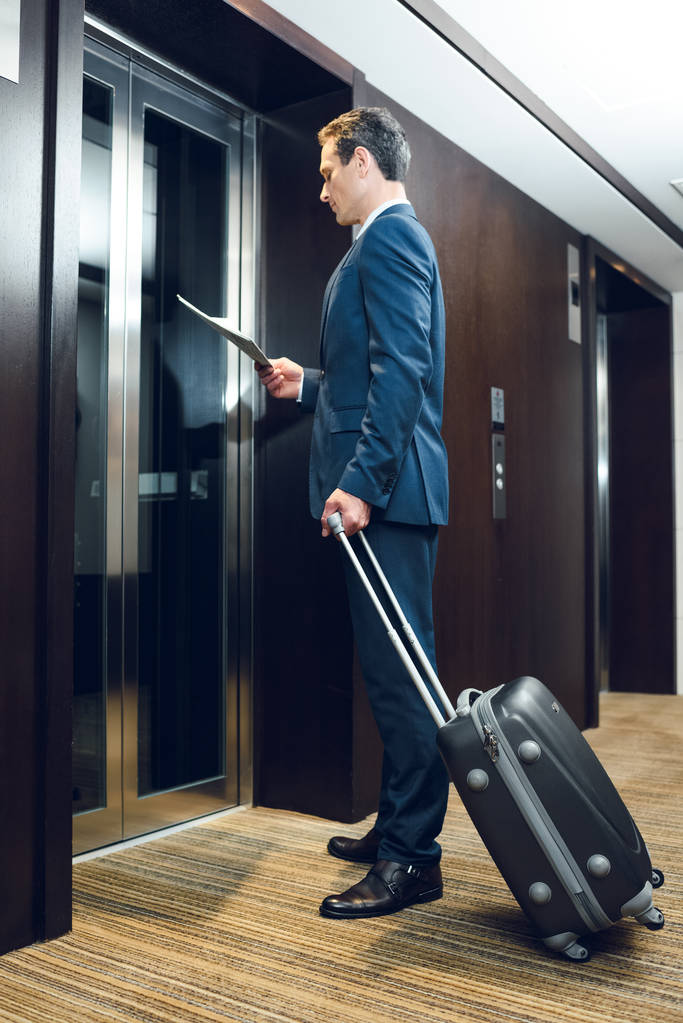 бізнесмен чекає на готельний ліфт
 - Фото, зображення
