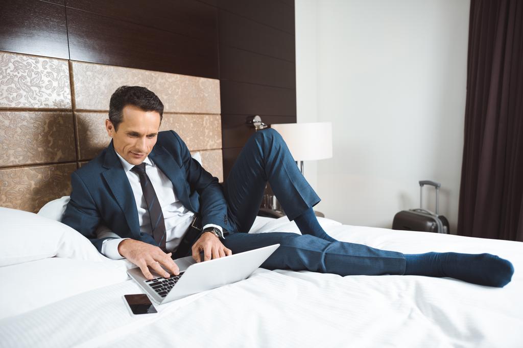 Geschäftsmann mit Laptop im Bett - Foto, Bild