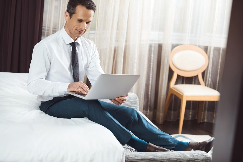 бизнесмен на кровати с помощью ноутбука
 - Фото, изображение