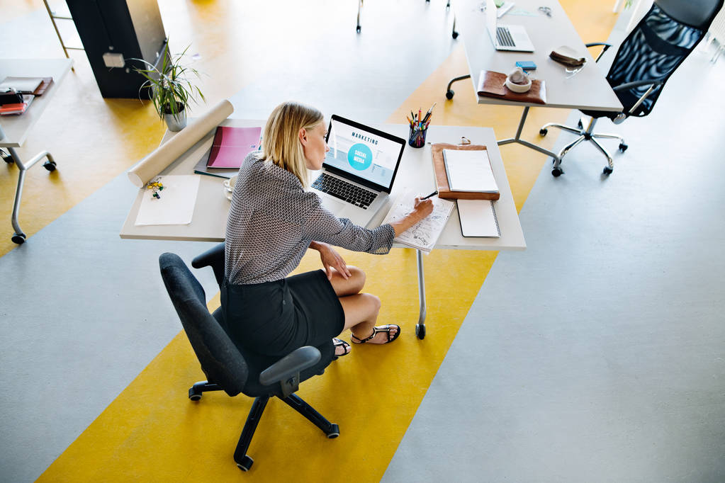 Geschäftsfrau mit Laptop in ihrem Büro am Schreibtisch, arbeitet. - Foto, Bild