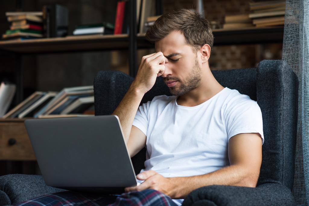 zmęczony człowiek korzysta z laptopa - Zdjęcie, obraz