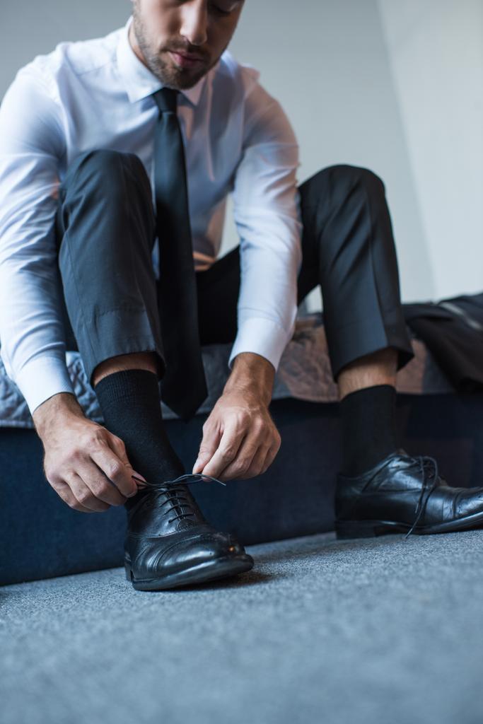 бизнесмен завязывает шнурки
 - Фото, изображение