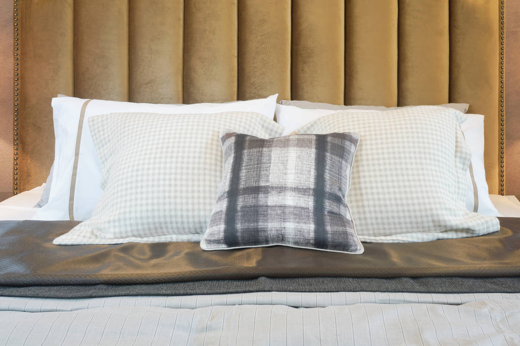 Quarto de estilo decorativo de luxo com travesseiros padrão verificados na cama
 - Foto, Imagem
