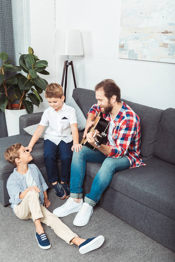 ギターを弾く人の息子を持つ父 - 写真・画像