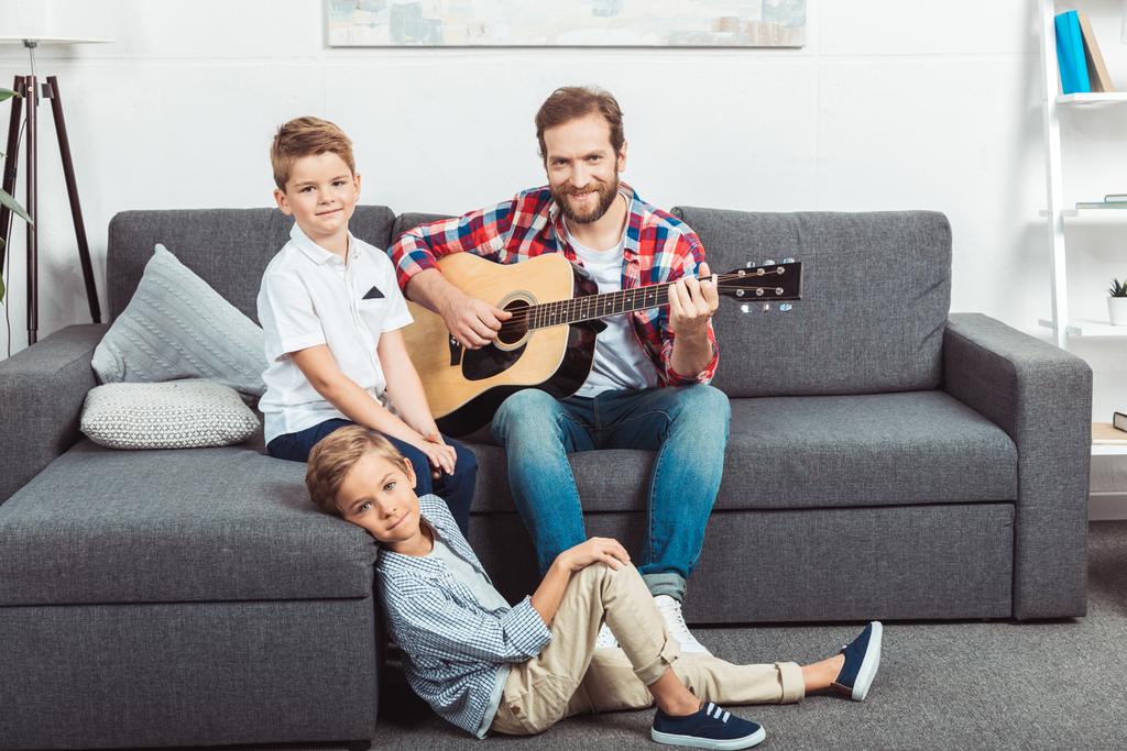 padre con hijos tocando la guitarra
 - Foto, imagen