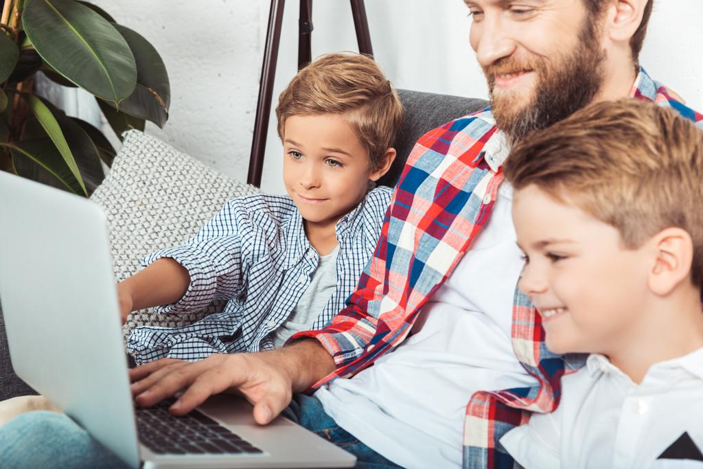 pai com filhos usando laptop
 - Foto, Imagem