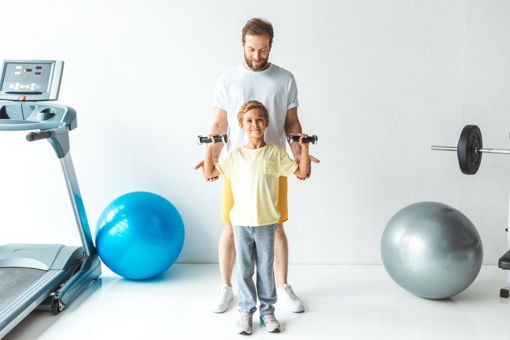 padre e hijo entrenando con pesas
 - Foto, Imagen
